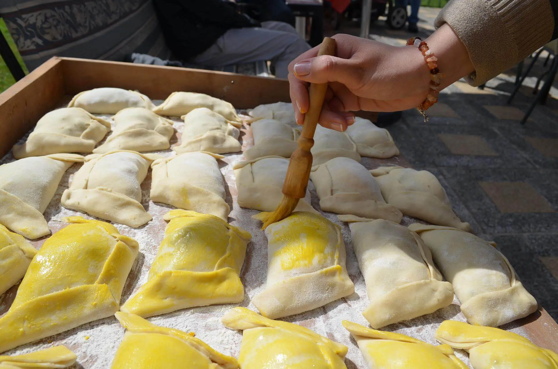 chile dumpling being painted with egg wash