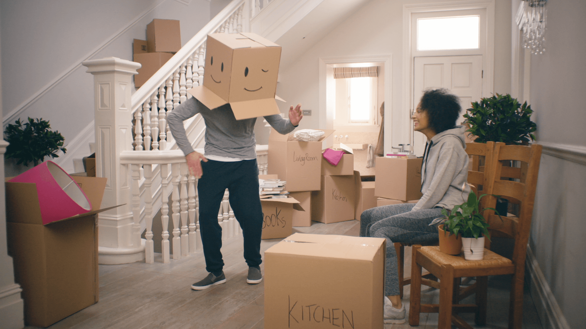 man wearing box on head with smiley face