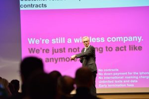 erich speaking at conference with pink background