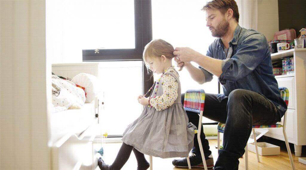 dad braiding little girl's hair