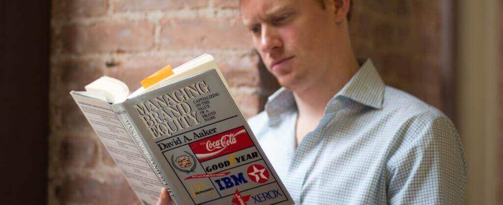 man reading managing brand equity book