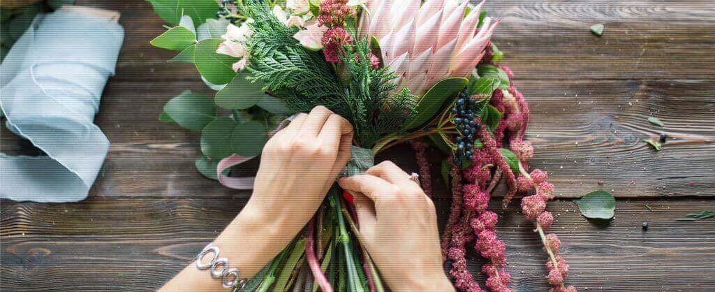 woman putting a bouquet of flowers together