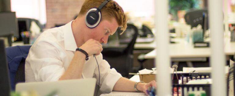 Man working at his desk with a headset on