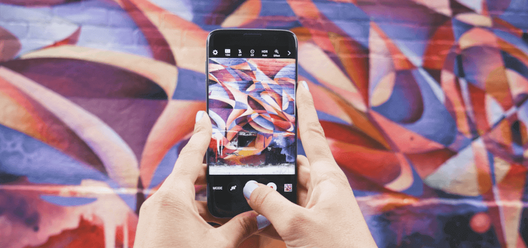 Smartphone prenant une photo d'un mur artistique