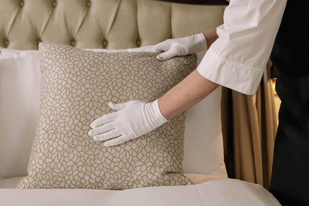 housekeeper fluffing pillow