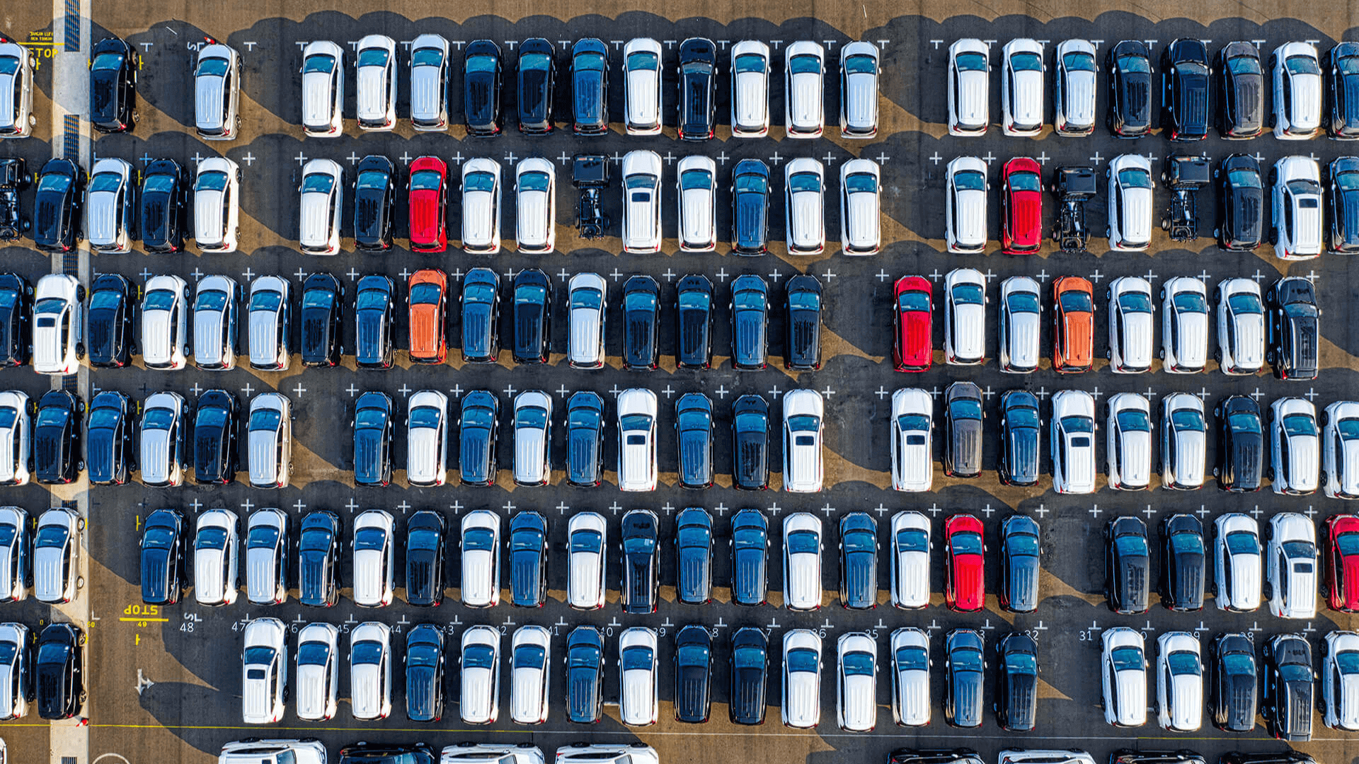 a parking lot with a red car in the middle