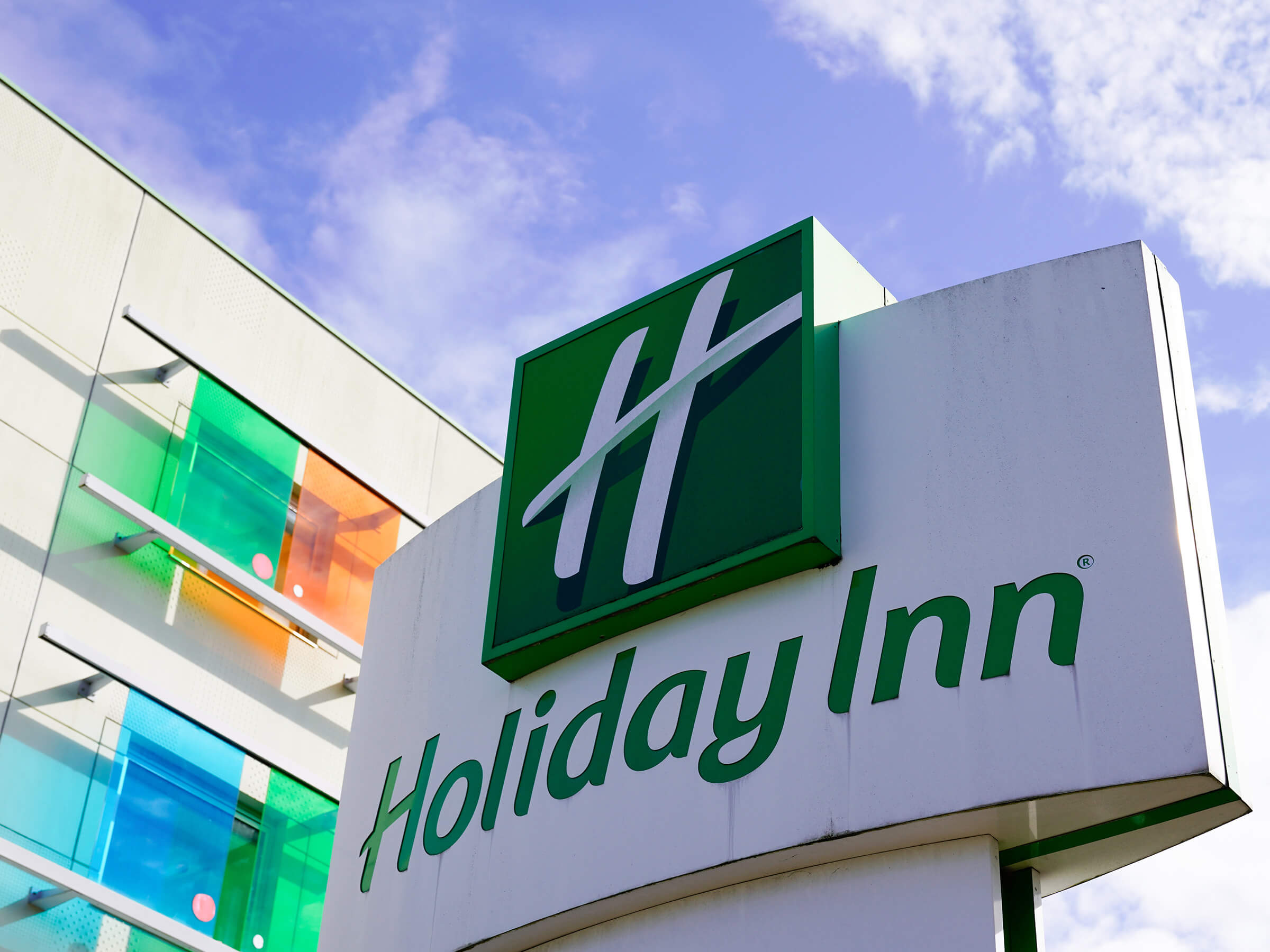 a holiday inn sign with a blue sky in the background