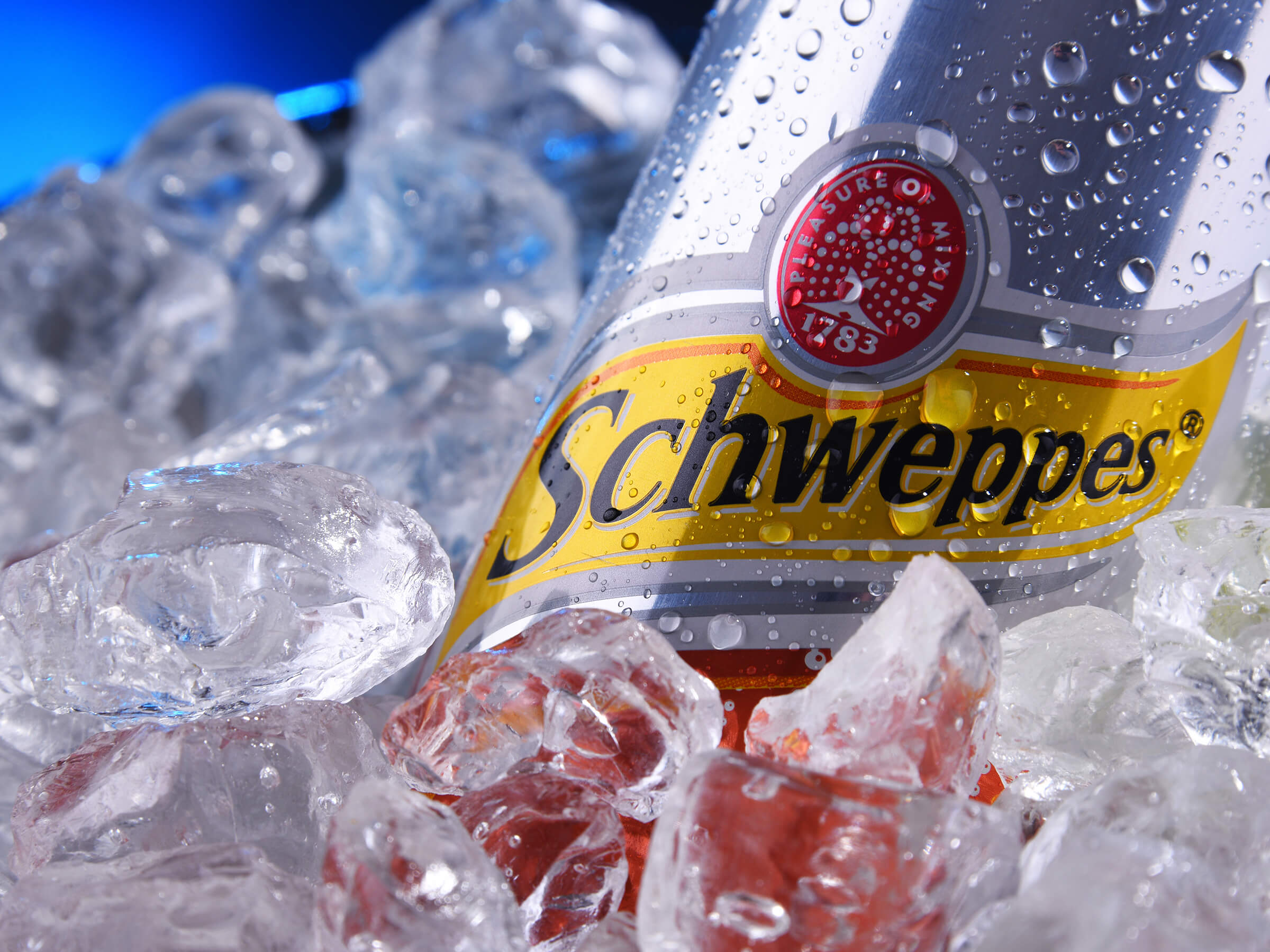 A can of Schweppes in an ice bath