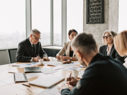 Executives reviewing financial charts in a boardroom meeting on AI investment and ROI